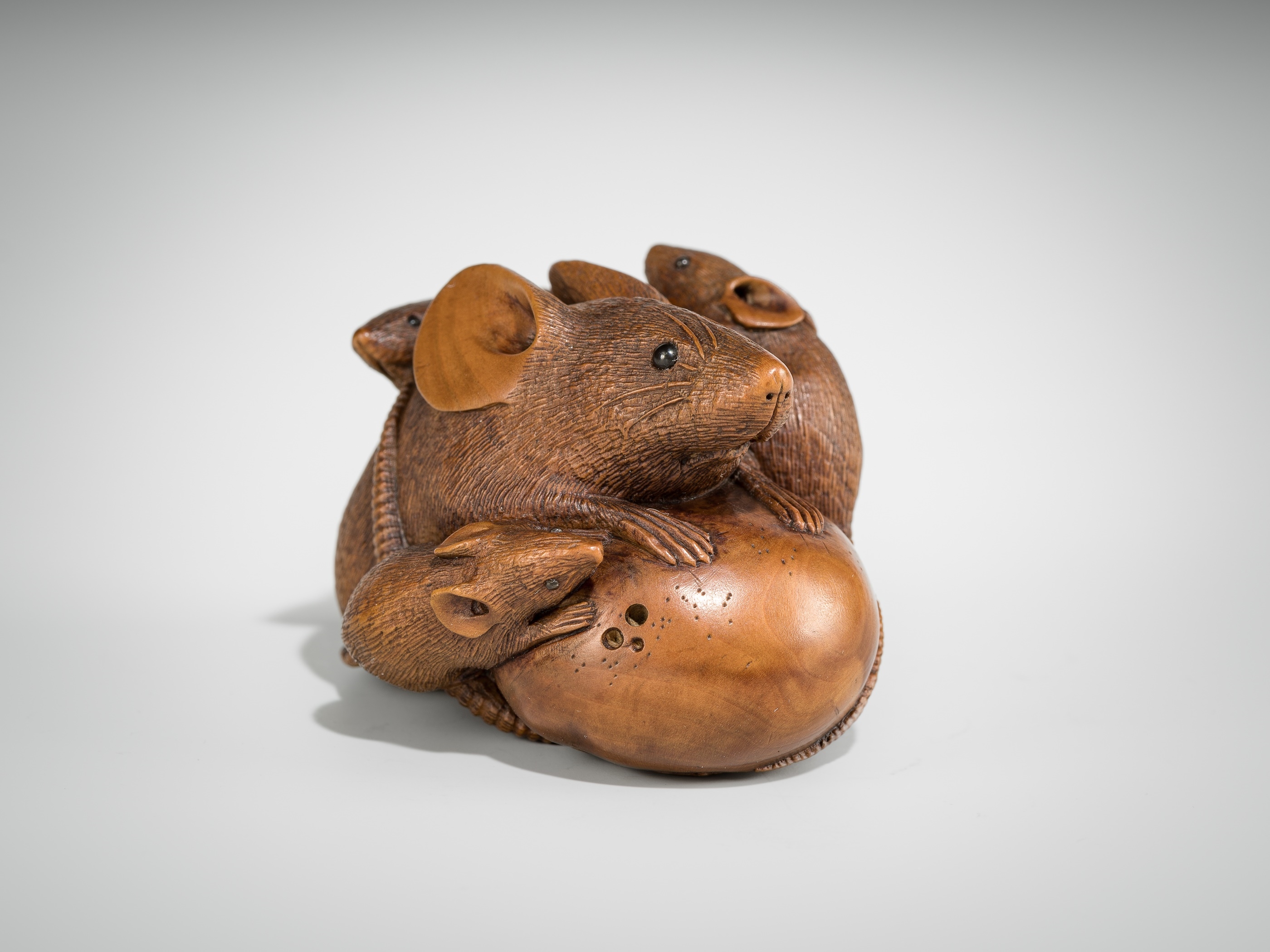 Artwork by Hokyudo Itsumin, ITSUMIN: A FINE WOOD NETSUKE OKIMONO OF A GROUP OF RATS WITH PERSIMMON, Made of wood
