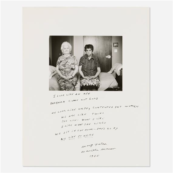 A black-and-white photograph of two seated women with handwritten text below.
