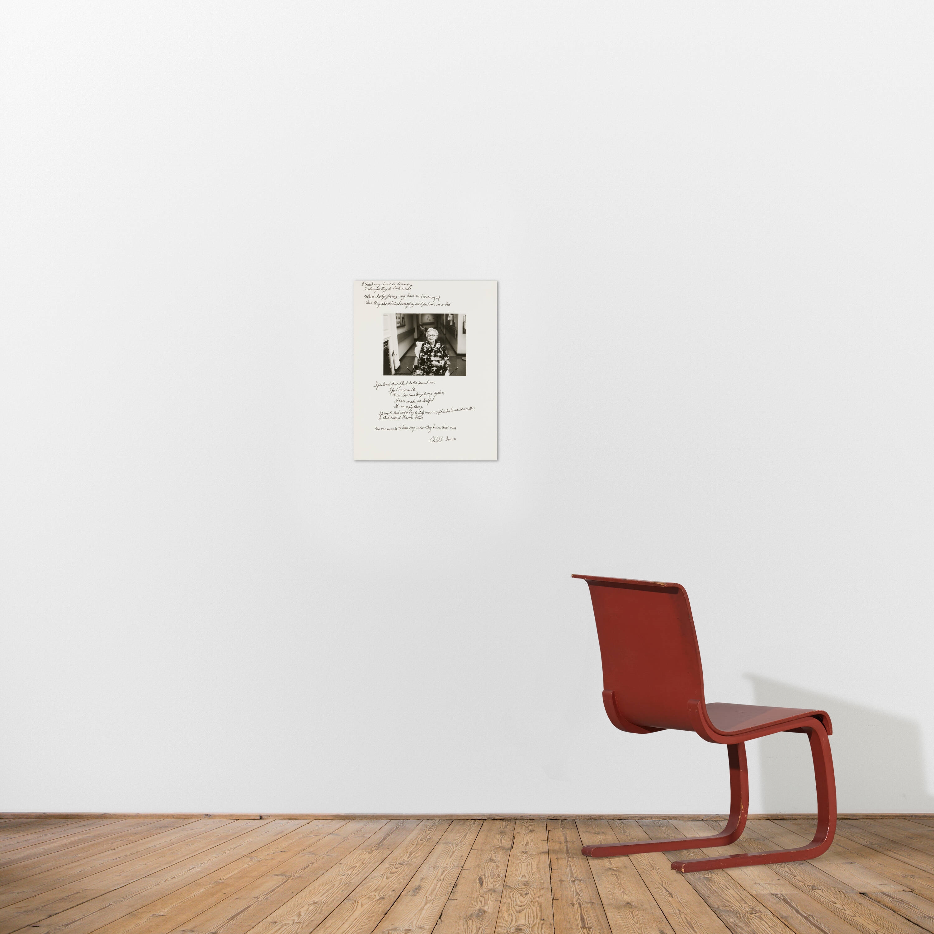 A black-and-white portrait of an elderly woman in a wheelchair, framed by handwritten text.