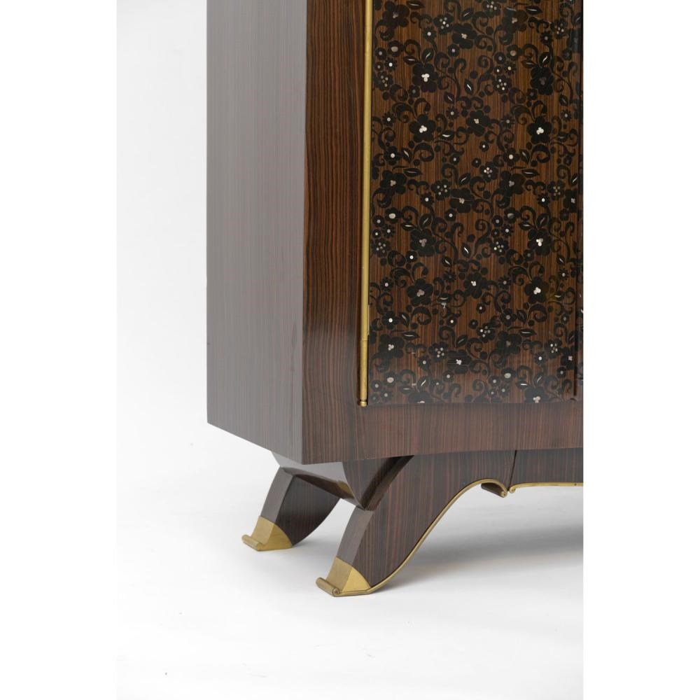Artwork by Jules Leleu, gilt bronze edging, Made of Important meuble à hauteur d’appui en ébène de Macassar, ouvrant à trois portes ornées d’un riche décor de rinceaux fleuris en marqueterie d’ébène et de nacre ; plateau supérieur à gradins, portes et piétement soulignés de baguettes en bronze doré ; pieds à réception de sabots en bronze