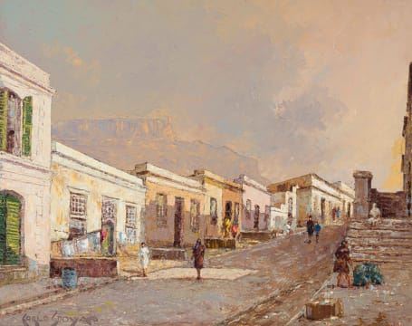 A sun-drenched street scene in a historic town with distant mountains under a hazy sky.