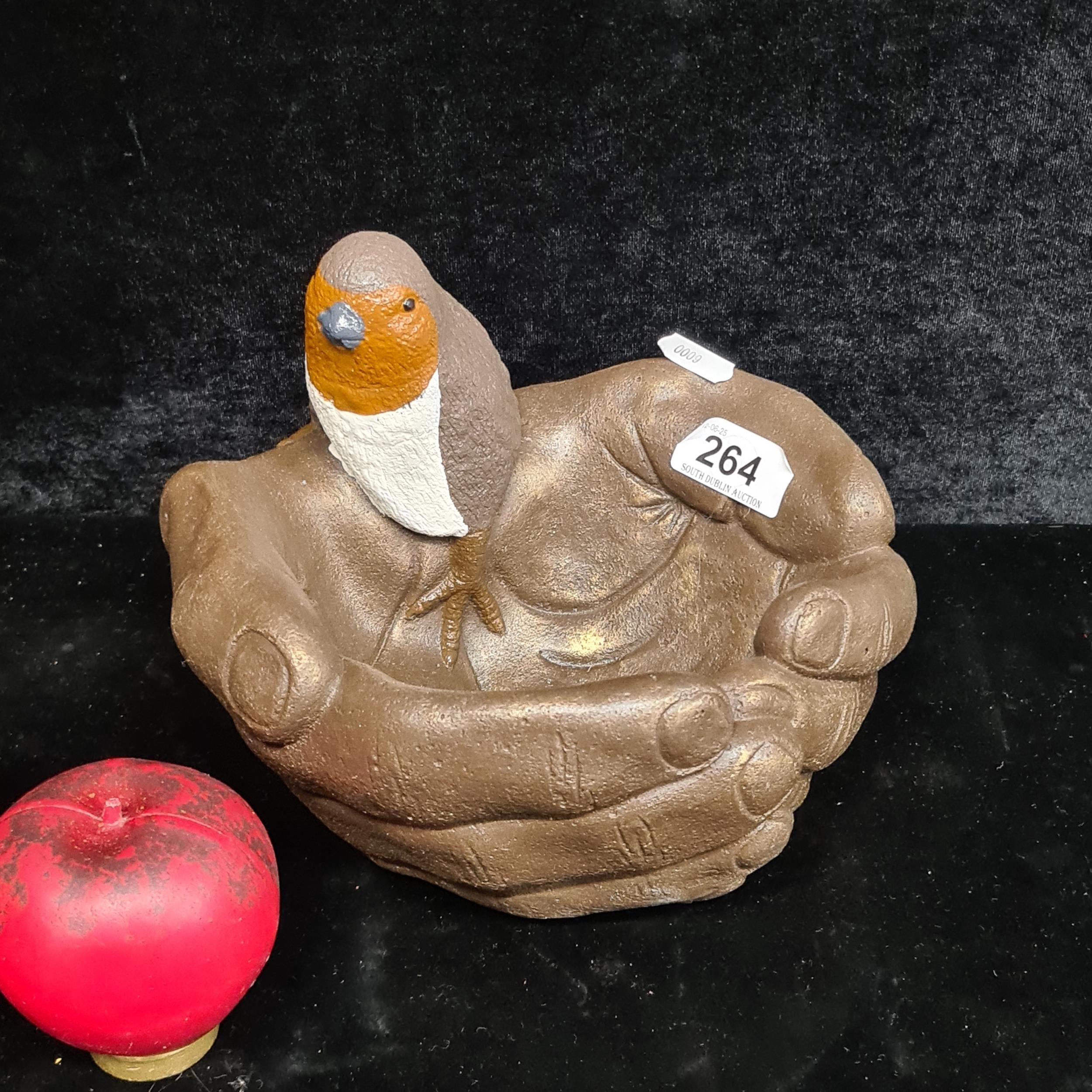 Artwork by Robin , A decorative heavy stone bird bath sculpture featuring a robin perched within two cupped hands., Made of sculpture