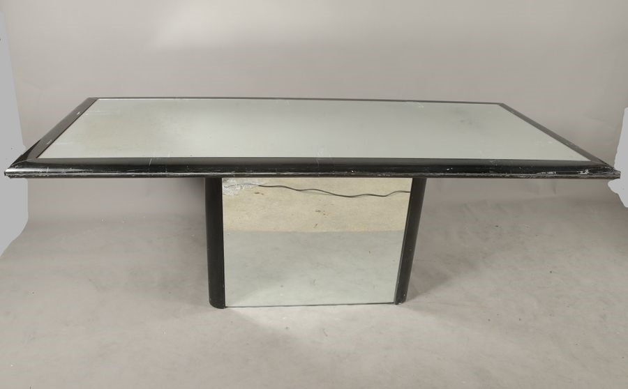 Artwork by Claude Saint-Pierre, RECTANGULAR dining-room table, circa 1980, in black melamine-coated wood, resting on a high pedestal with rounded uprights, top and base adorned with mirrors, Made of black melamine-coated wood
