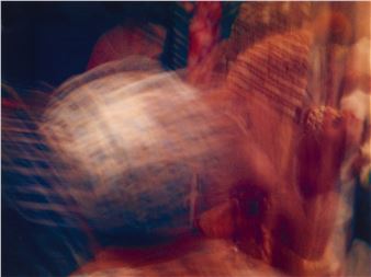 A motion-blurred close-up of a person's face in warm, hazy light.