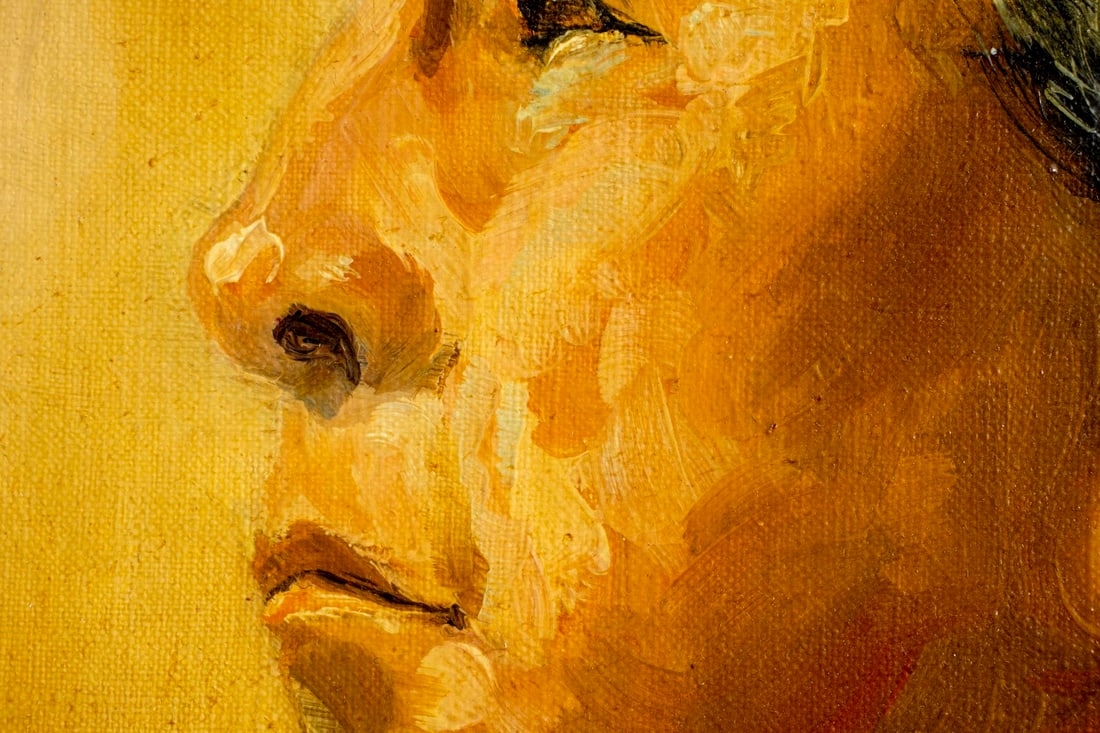 A solemn profile portrait of a person in traditional attire against a warm, textured background.