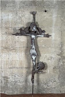 A metal cross with birds and flowers on it.