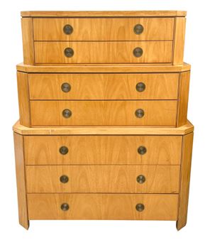 A stacked wooden chest of drawers featuring three tiers with circular metal pulls.