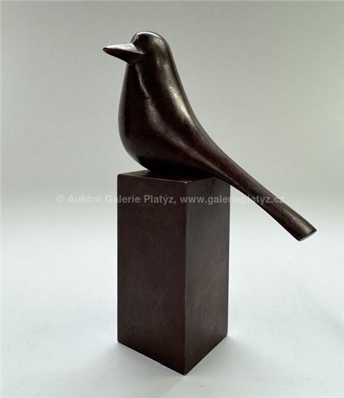 A bronze sculpture of a bird sitting on top of a block.