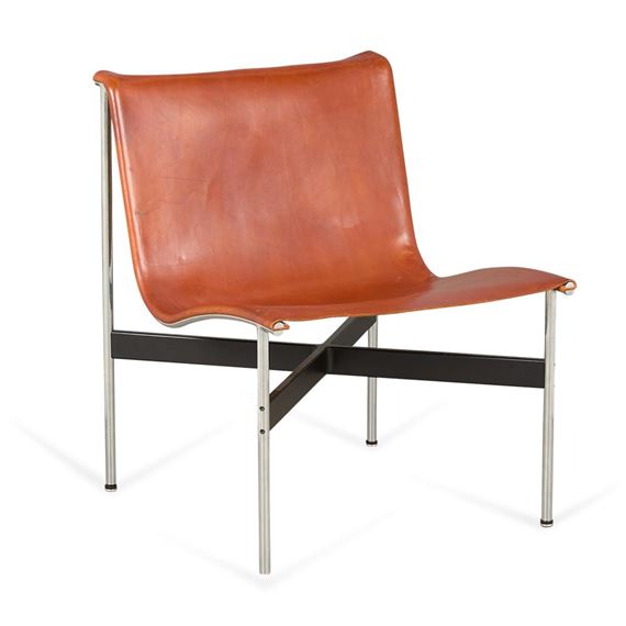 A minimalist lounge chair featuring a smooth brown leather seat and backrest supported by a sleek chrome frame.