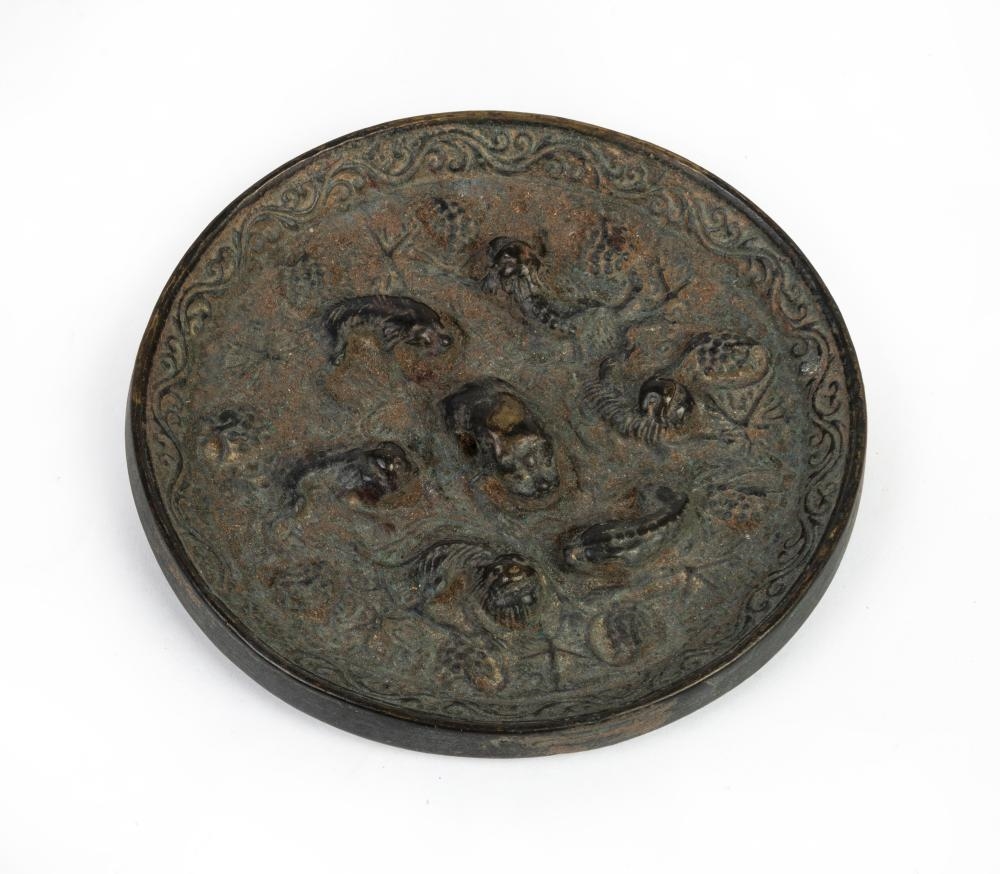 Artwork by Chinese School, A Chinese bronze 'lion and grapevine' mirror, Made of Bronze