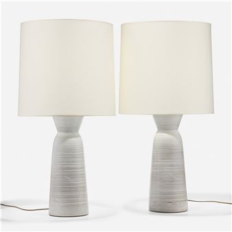 A pair of minimalist ceramic table lamps with textured bases and simple shades.