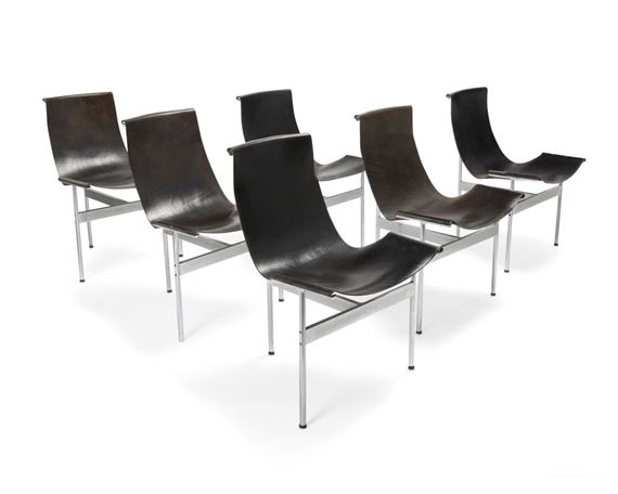 A set of five identical black leather chairs with chrome frames arranged in a staggered row.