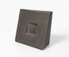 A minimalist geometric sculpture featuring a dark, textured cube with a recessed square center.