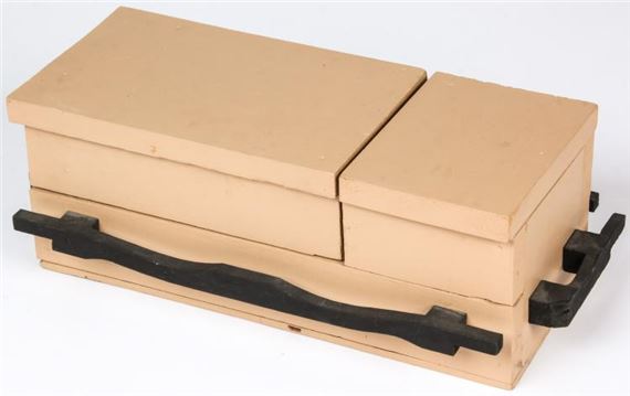 A minimalist product shot of a beige rectangular box with black handles.