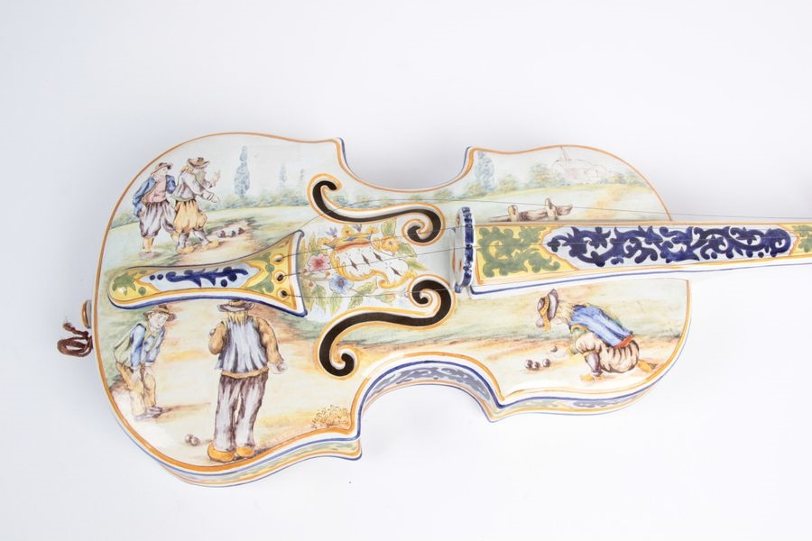 Artwork by Henriot Quimper, Earthenware violin with polychrome decoration depicting Bretons playing boule bretonne, Made of Earthenware