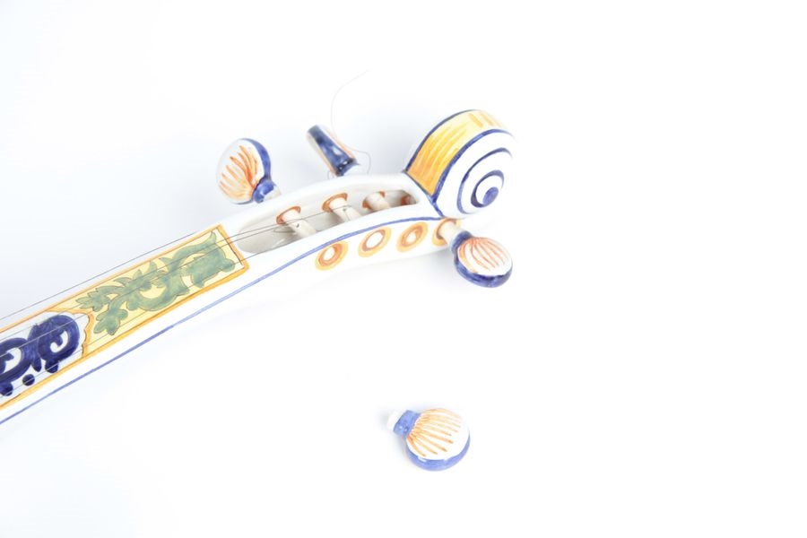 Artwork by Henriot Quimper, Earthenware violin with polychrome decoration depicting Bretons playing boule bretonne, Made of Earthenware