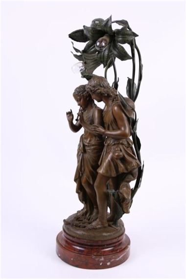 A bronze sculpture of two figures entwined with a large flower, resting on a wooden base.