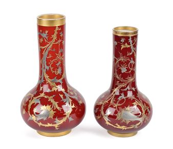 A pair of elegant red vases featuring intricate gold and silver floral patterns.
