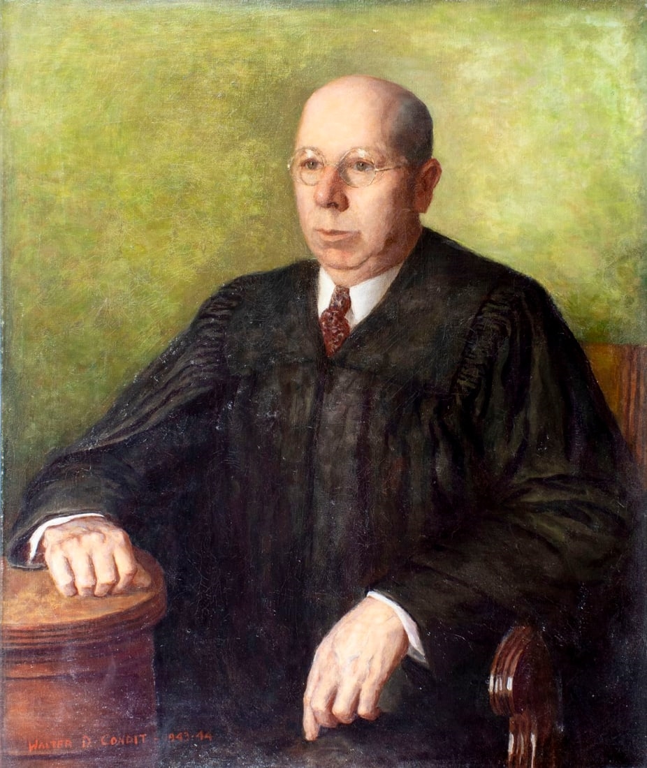 A formal portrait of a seated figure in judicial robes against a muted green background.