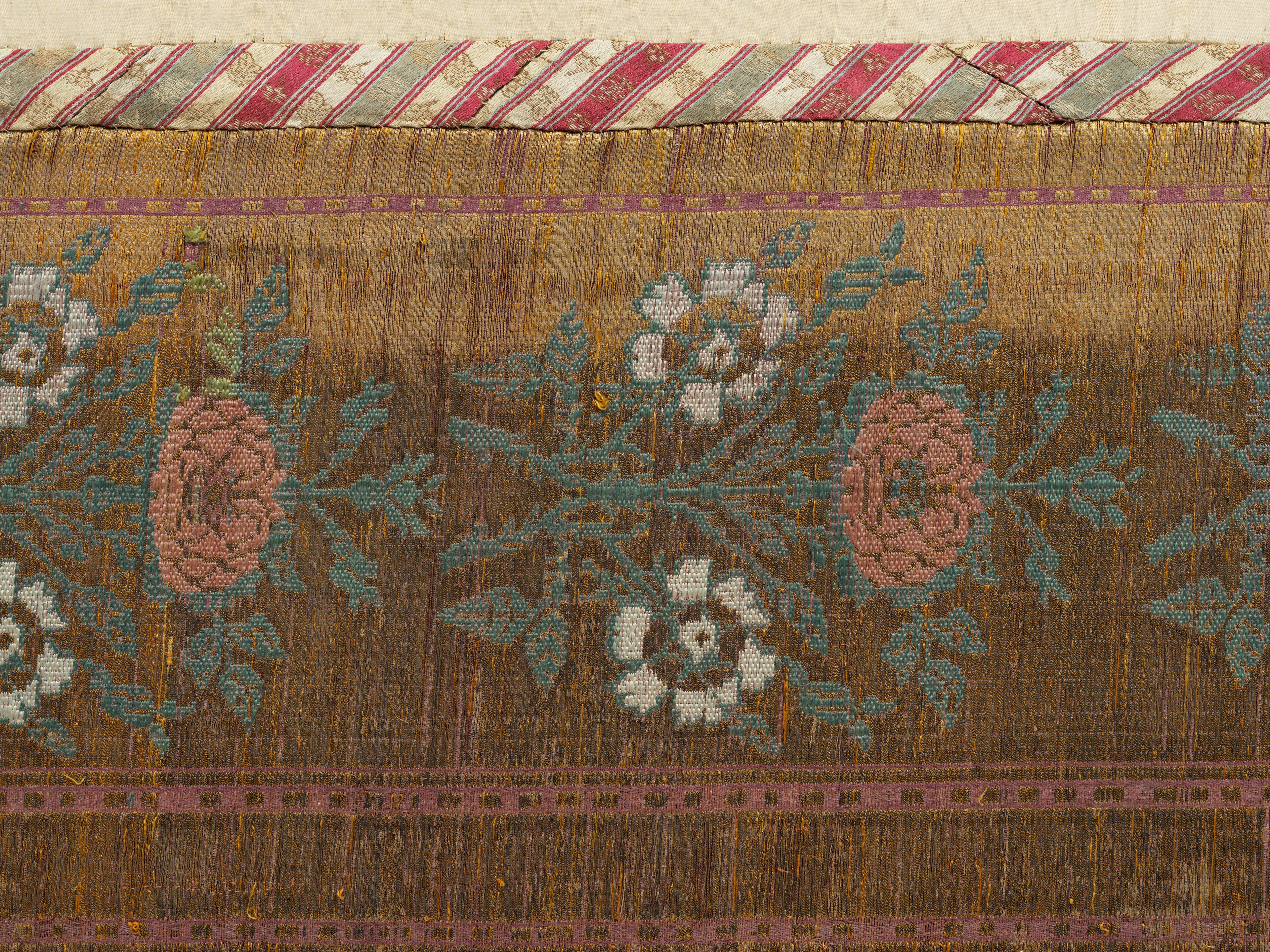 Artwork by Persian School, 19th Century, An impressive Qajar for Ashura day celebrations, Made of Rectangular form, woven and embroidered in polychrome silk and metal thread with the Imam Husayn mounted on horseback carrying a shield and lance, the head and upper body of a child behind him, spandrels above, the border with a repeat design of floral sprays, above and below bands of inscription-filled cartouches, woven silk edging