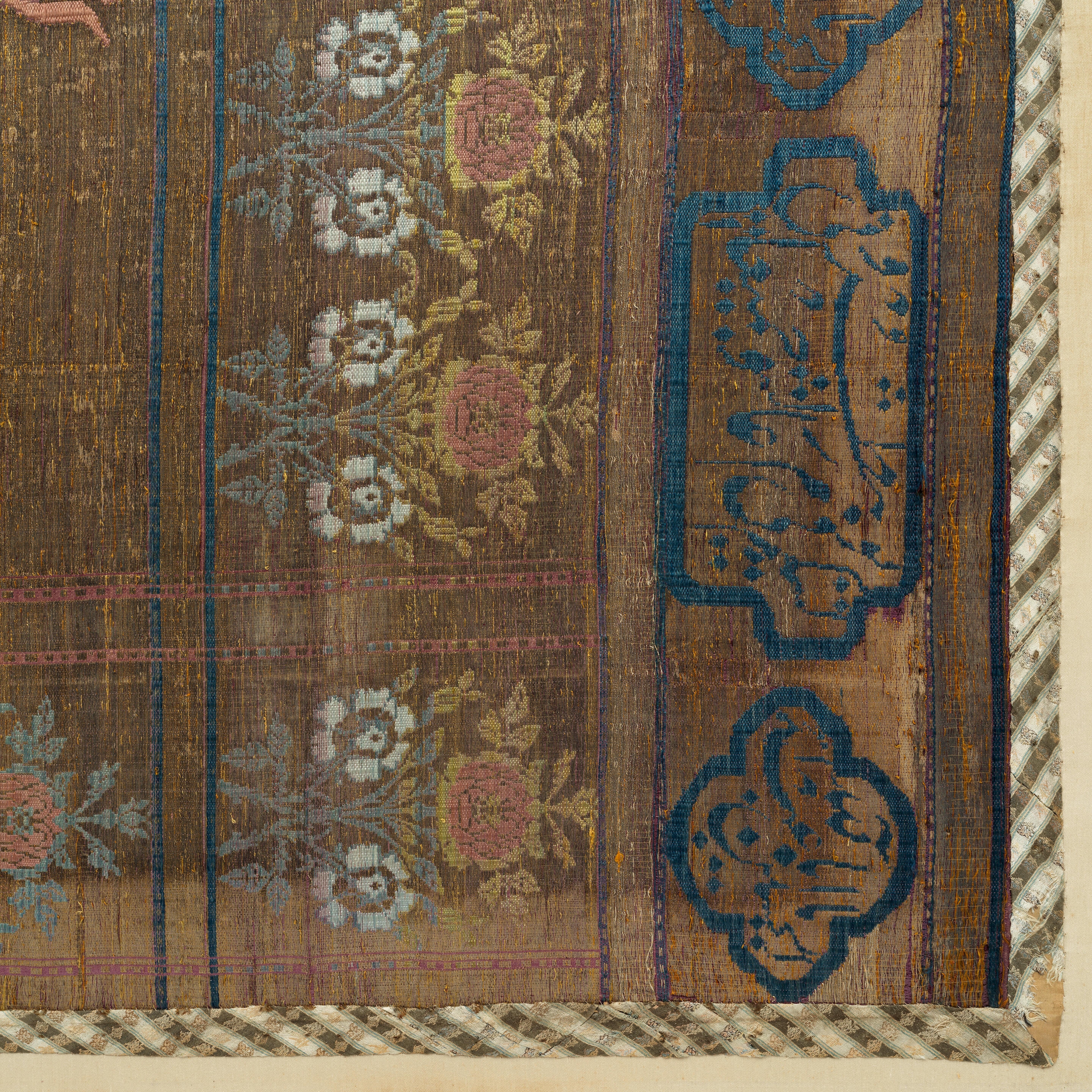 Artwork by Persian School, 19th Century, An impressive Qajar for Ashura day celebrations, Made of Rectangular form, woven and embroidered in polychrome silk and metal thread with the Imam Husayn mounted on horseback carrying a shield and lance, the head and upper body of a child behind him, spandrels above, the border with a repeat design of floral sprays, above and below bands of inscription-filled cartouches, woven silk edging