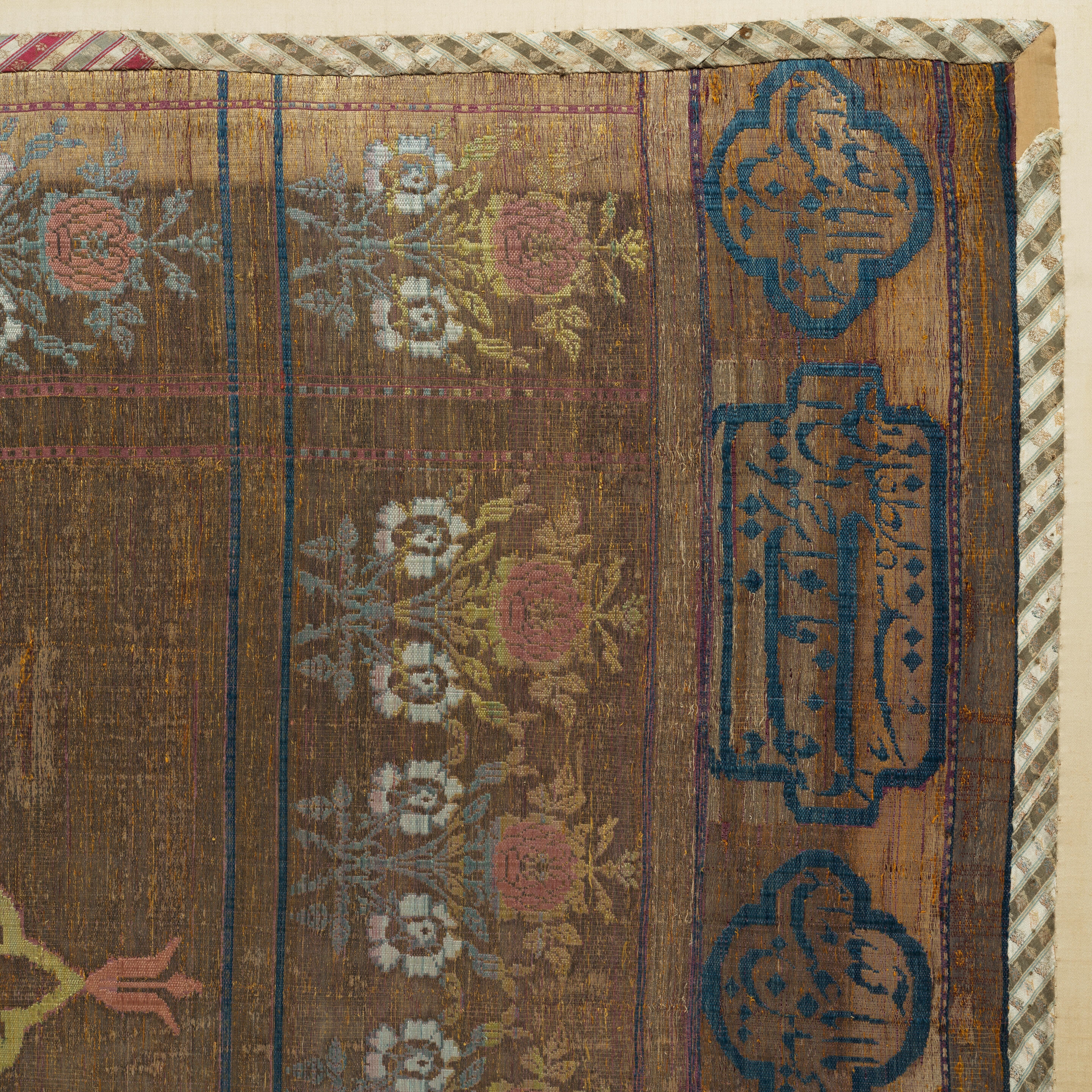 Artwork by Persian School, 19th Century, An impressive Qajar for Ashura day celebrations, Made of Rectangular form, woven and embroidered in polychrome silk and metal thread with the Imam Husayn mounted on horseback carrying a shield and lance, the head and upper body of a child behind him, spandrels above, the border with a repeat design of floral sprays, above and below bands of inscription-filled cartouches, woven silk edging