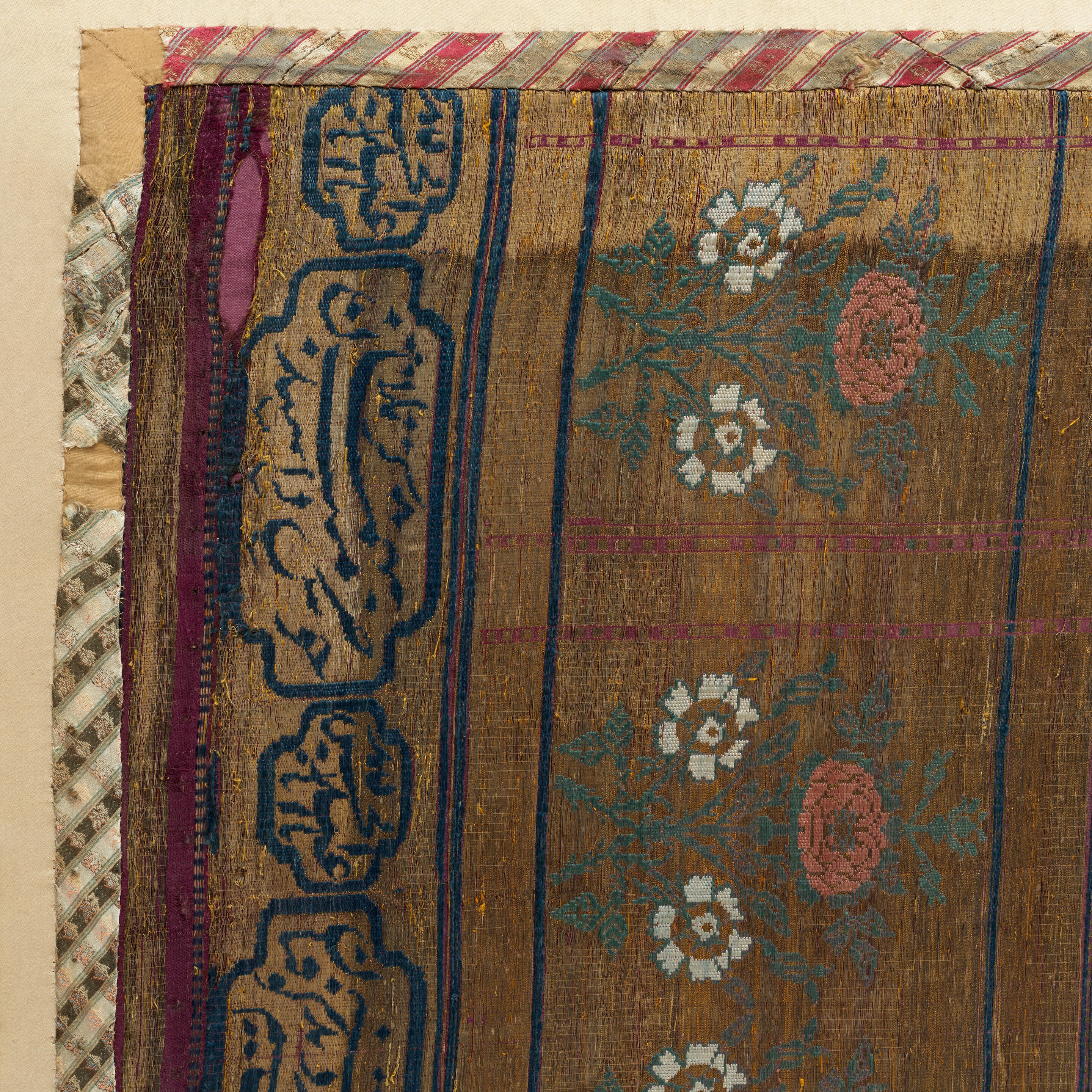 Artwork by Persian School, 19th Century, An impressive Qajar for Ashura day celebrations, Made of Rectangular form, woven and embroidered in polychrome silk and metal thread with the Imam Husayn mounted on horseback carrying a shield and lance, the head and upper body of a child behind him, spandrels above, the border with a repeat design of floral sprays, above and below bands of inscription-filled cartouches, woven silk edging