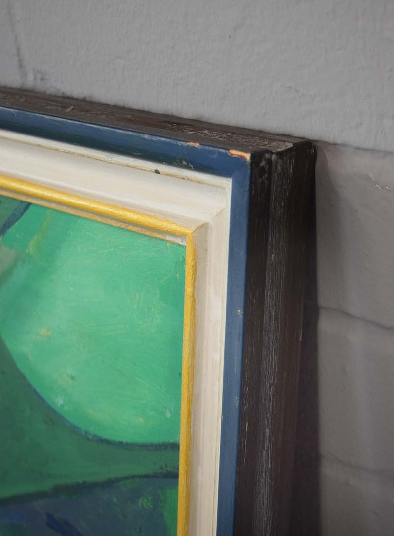 A geometric green and blue painting of a tropical plant in a dark frame.