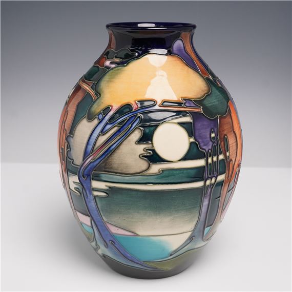 A ceramic vase featuring a stylized landscape with a moon and trees.