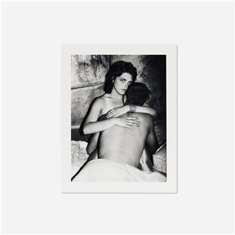 A black and white photograph of a woman embracing a man from behind, with her face turned toward the camera.