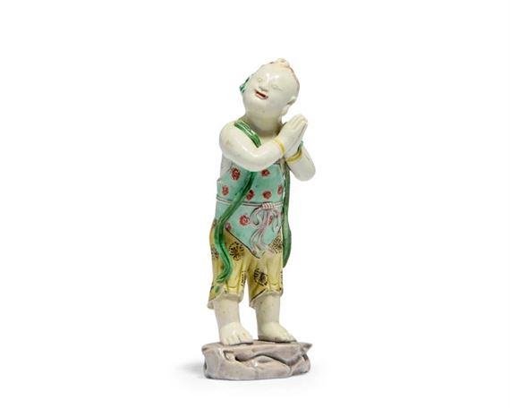 A Chinese famille verte biscuit figure of a boy by Chinese School, Kangxi period