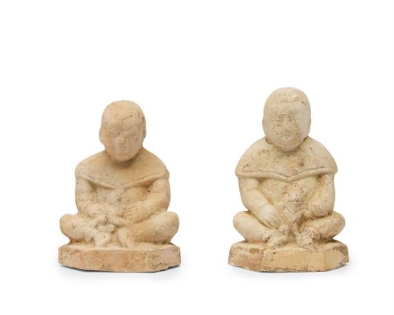 A pair of Chinese pottery figures of boys with animals