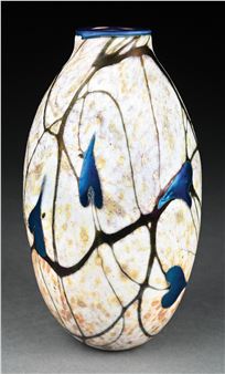 An absolutely gorgeous example of a Charles Lotton art glass vase. The 9" tall vase has a cream-colored background, with beautiful iridescent gold veining and speckling throughout. The vase is further decorated by a stunning blue leaf and vine pattern. A very remarkable example. The underside is signed "Charles Lotton 1981". It is free of cracks or chips