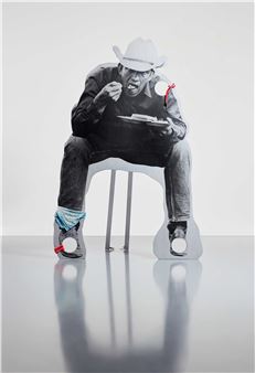 A black and white photo of a man sitting on a chair.