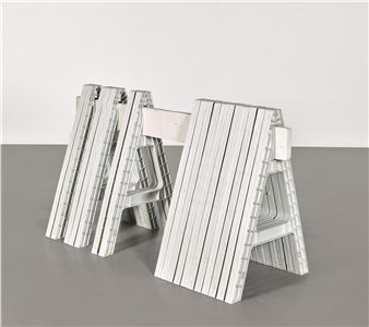 A set of three white folding chairs sitting on top of a table.