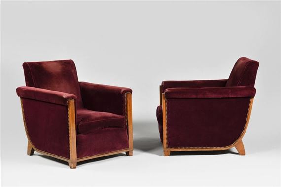 Living-room furniture comprising a rosewood and rosewood veneered sofa with solid curved back and armrests and a pair of cubic armchairs with sloping backs and flat uprights on curved legs, all upholstered in wine-red velvet - Jules Leleu