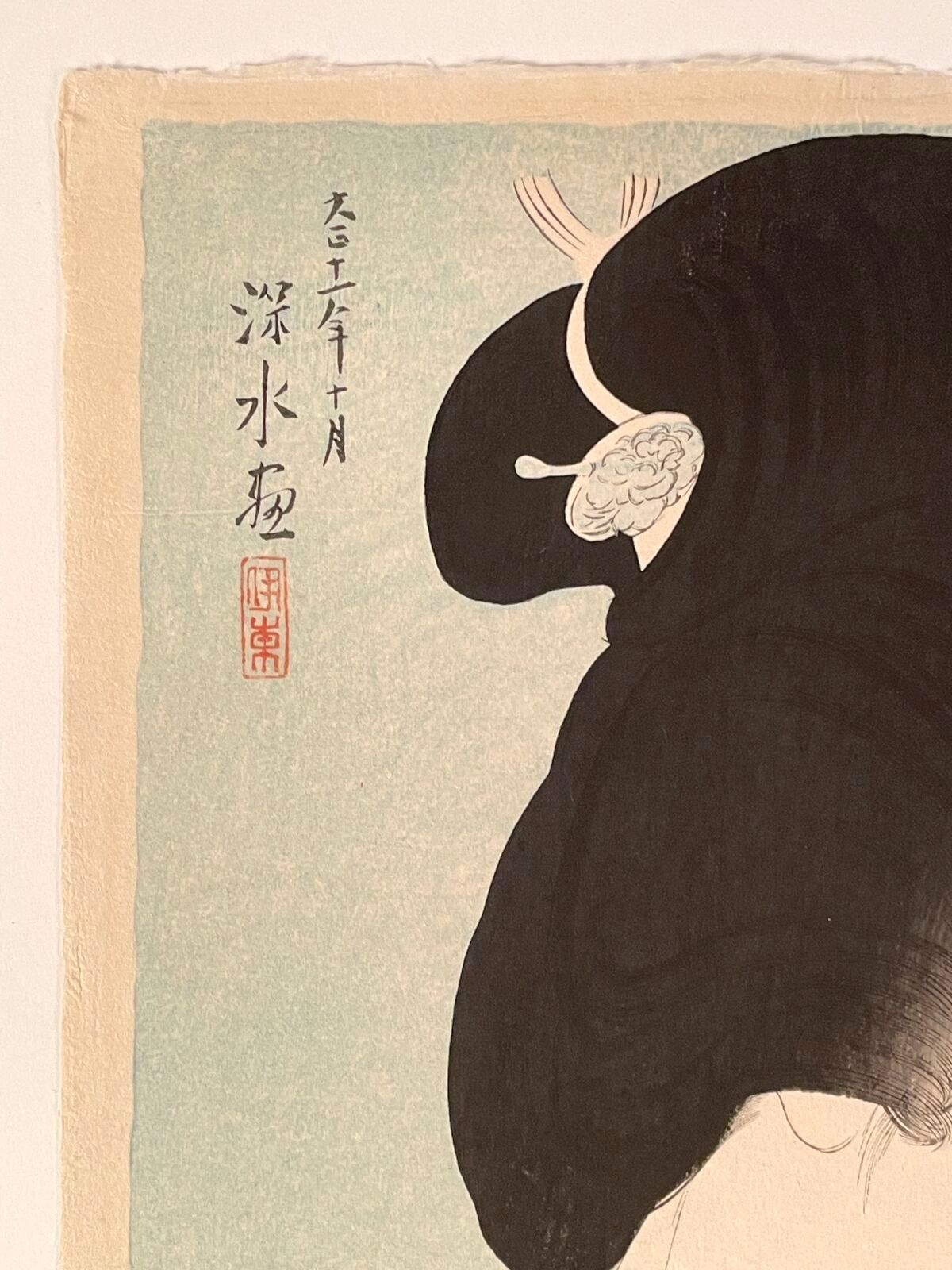 A profile portrait of a woman in traditional Japanese attire holding a small bowl.