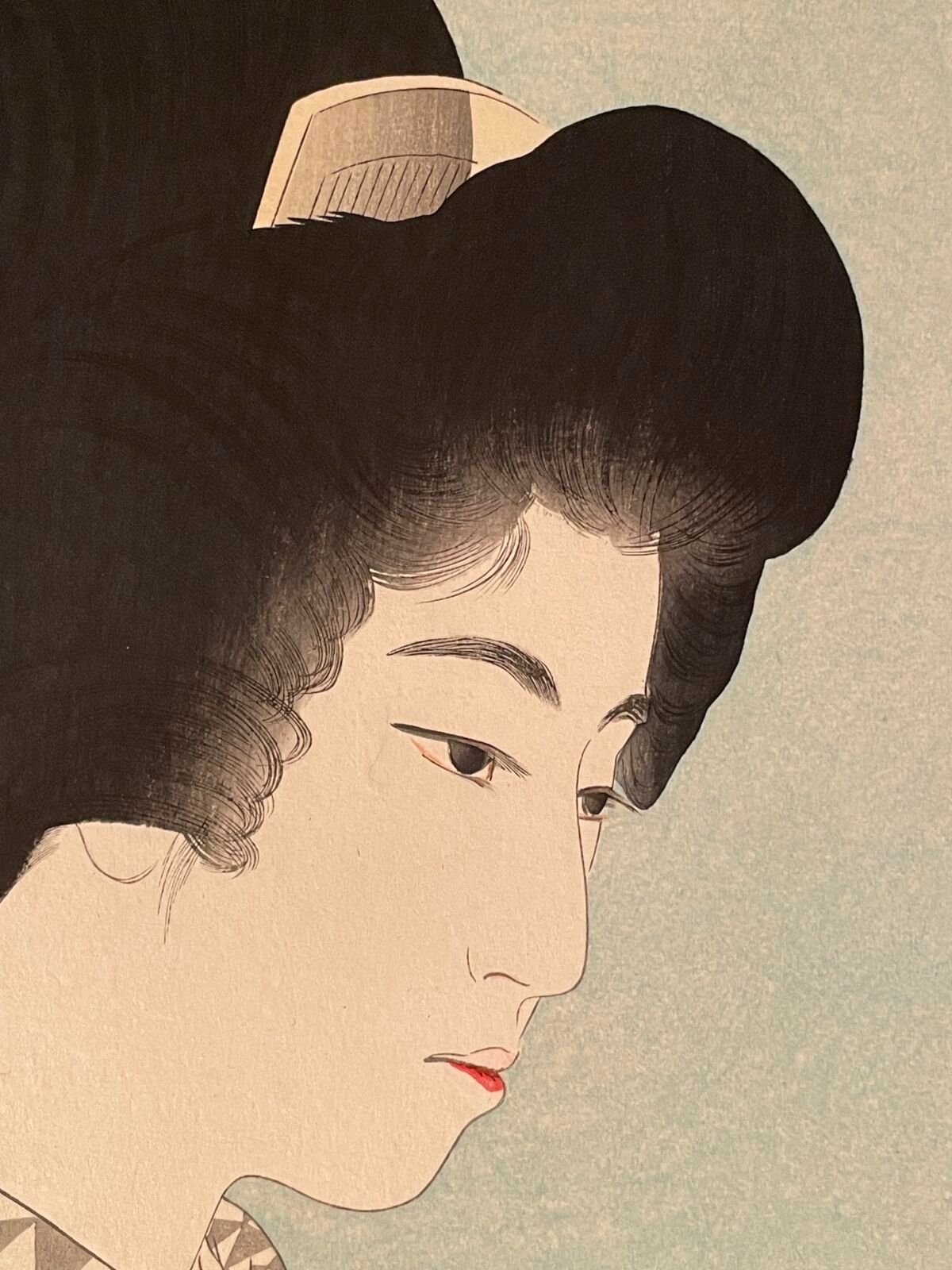 A profile portrait of a woman in traditional Japanese attire holding a small bowl.