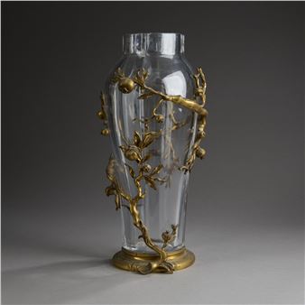 A glass vase with a gold leaf design on it.