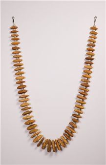 A wooden necklace composed of numerous small, irregularly shaped beads arranged in a U-shape.