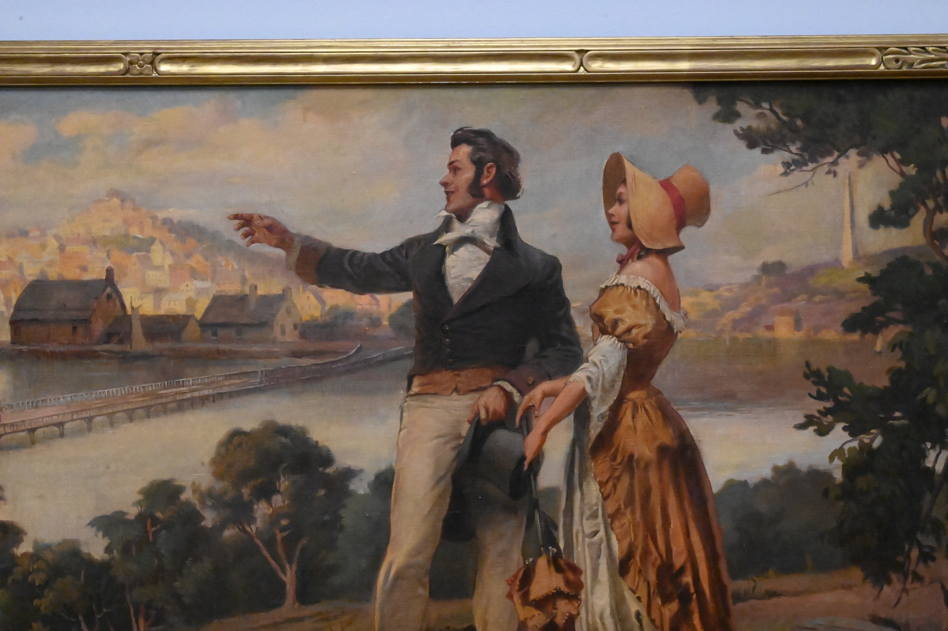 A romanticized landscape painting featuring a couple gazing at a distant city from a hillside.