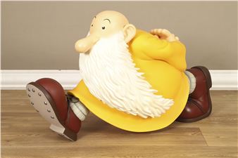 A yellow statue of a man with a long white beard sitting on the floor.