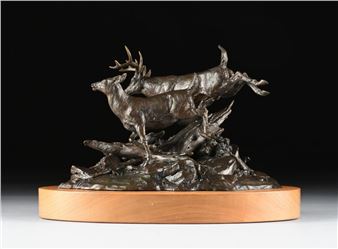 A bronze sculpture of two deer leaping over a rocky base, mounted on a wooden plinth.