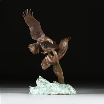 "A bronze sculpture of two birds in flight, captured mid-struggle over a rocky base."