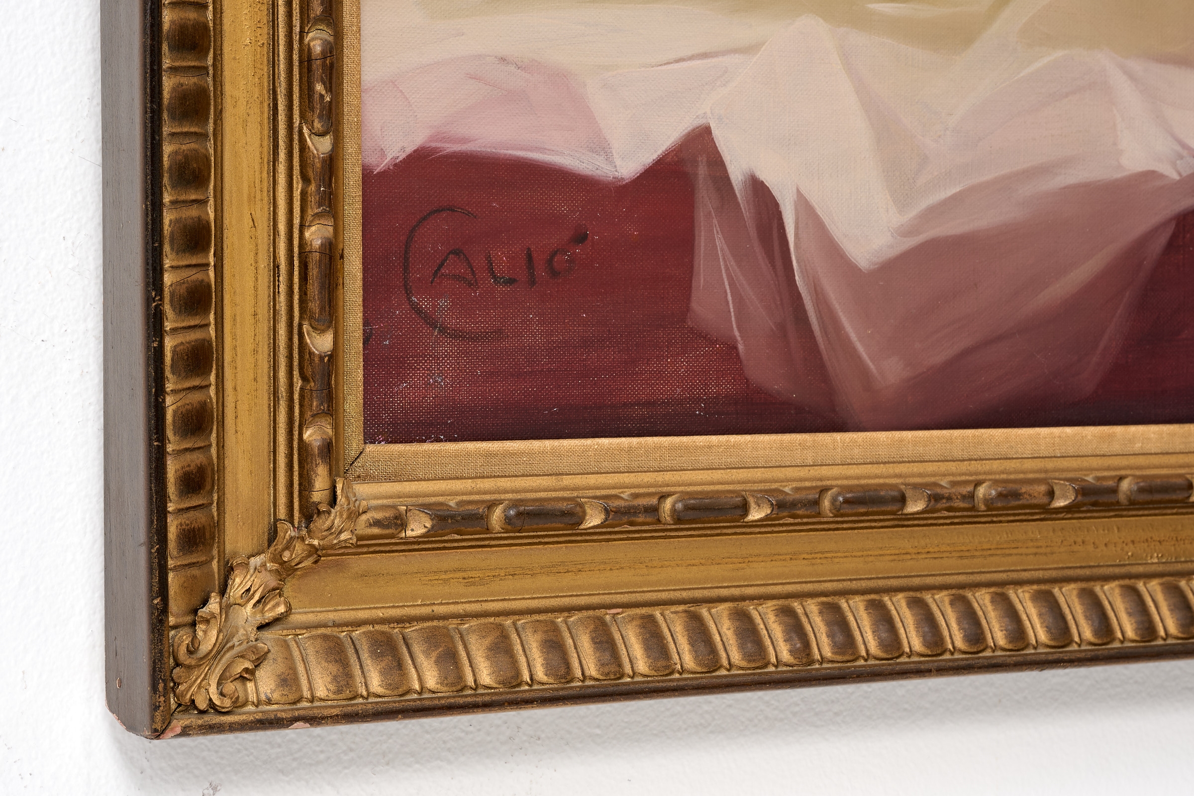 A classical oil painting of a reclining nude figure in a bed, framed in ornate gold.