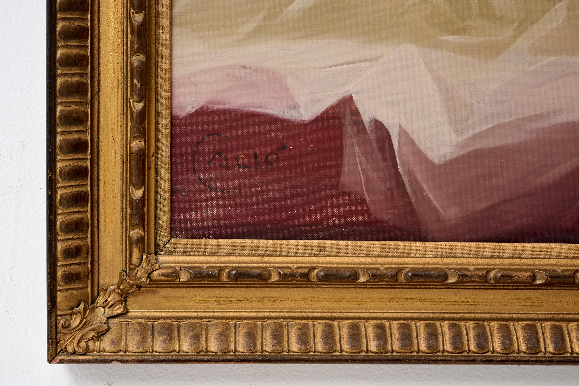 A classical oil painting of a reclining nude figure in a bed, framed in ornate gold.