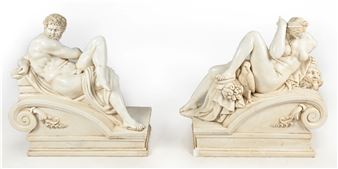 A pair of white marble statues of a man and a woman.