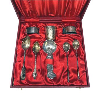 A set of silverware in a red box with a red velvet lining.