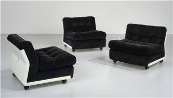 A set of three black and white chairs sitting next to each other.