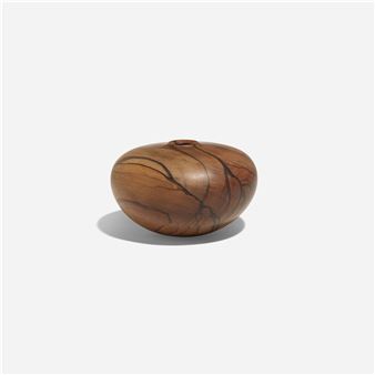 a wooden vase sitting on top of a white surface